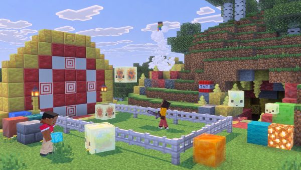 Minecraft Chaos Cubed scene: translucent sulfur cubes with faces sit in a fenced pen beside patterned block builds, a player mid-swing and TNT nearby